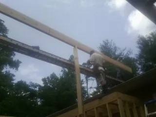 Carpenter setting a ridge beam over a new addition frame — Ice Dam Removal by Roofing Brothers in Hidden Valley