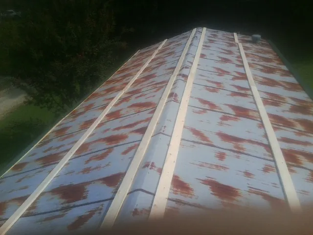 Rusted metal roof panels with new wood purlins before replacement — Storm Damage Roof Repair in Hidden Valley by Roofing Brothers