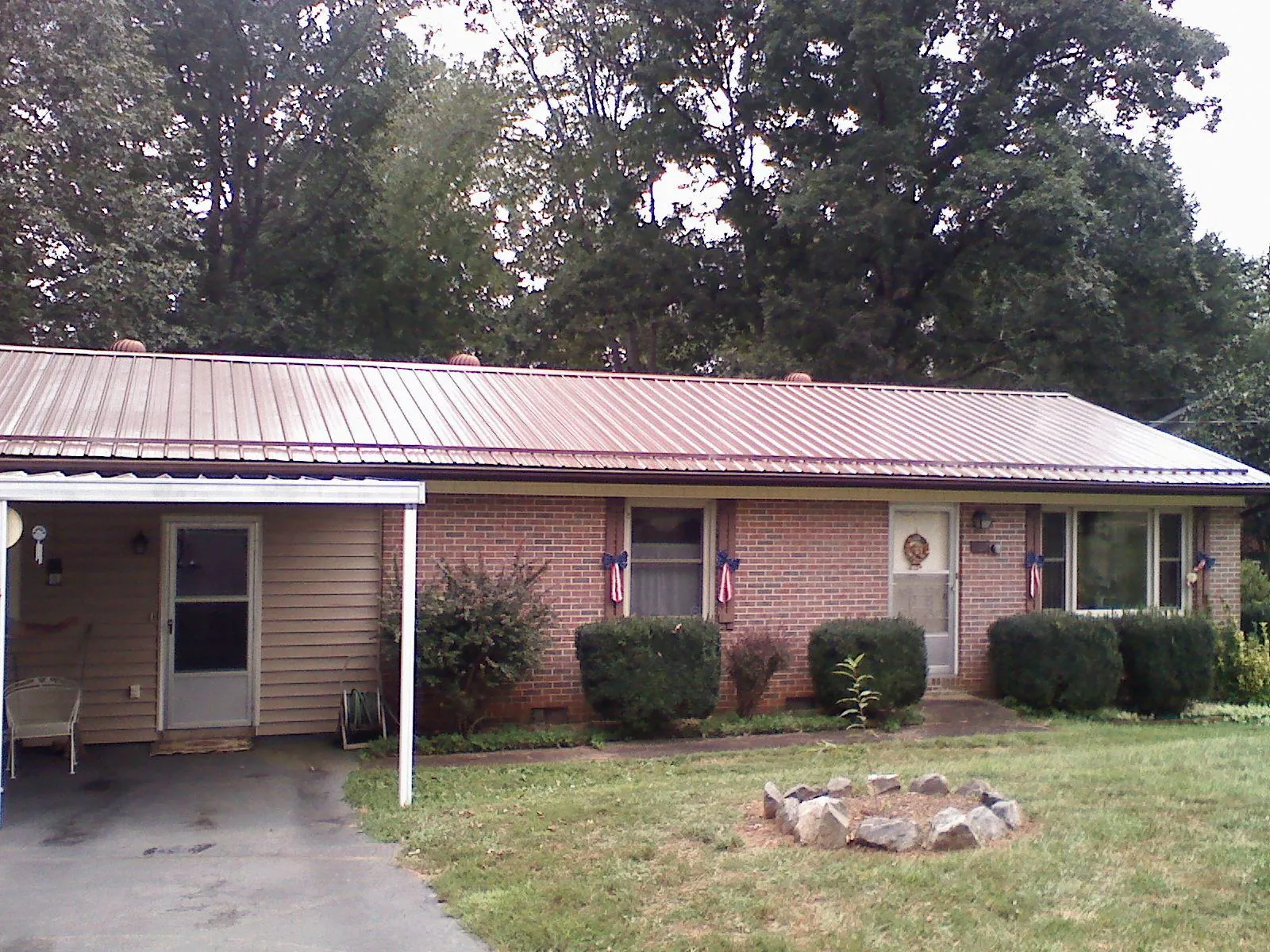 Bronze metal roof and carport on a brick ranch home — Roof Repair work by our crew in Hidden Valley